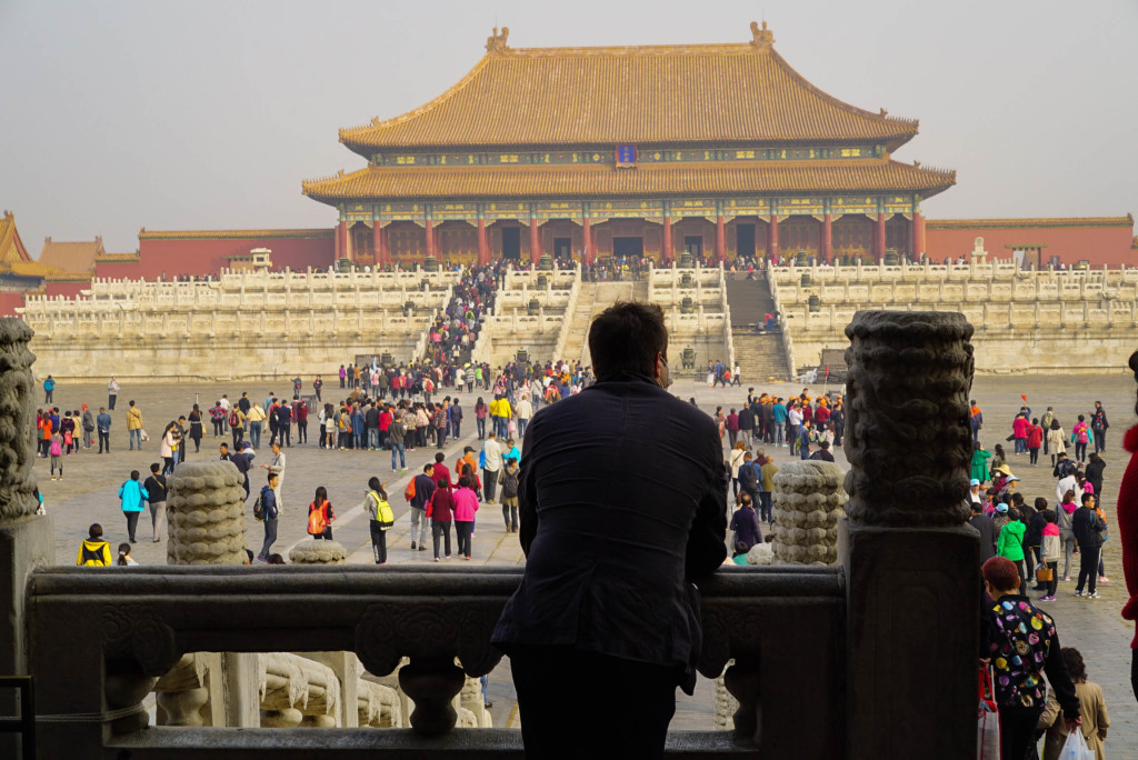 person looking at people in the balcony of a palace in Forbidden City