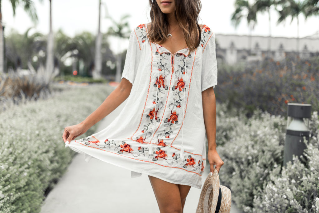 woman in white dress with floral design and sharing What to Pack for Italy 