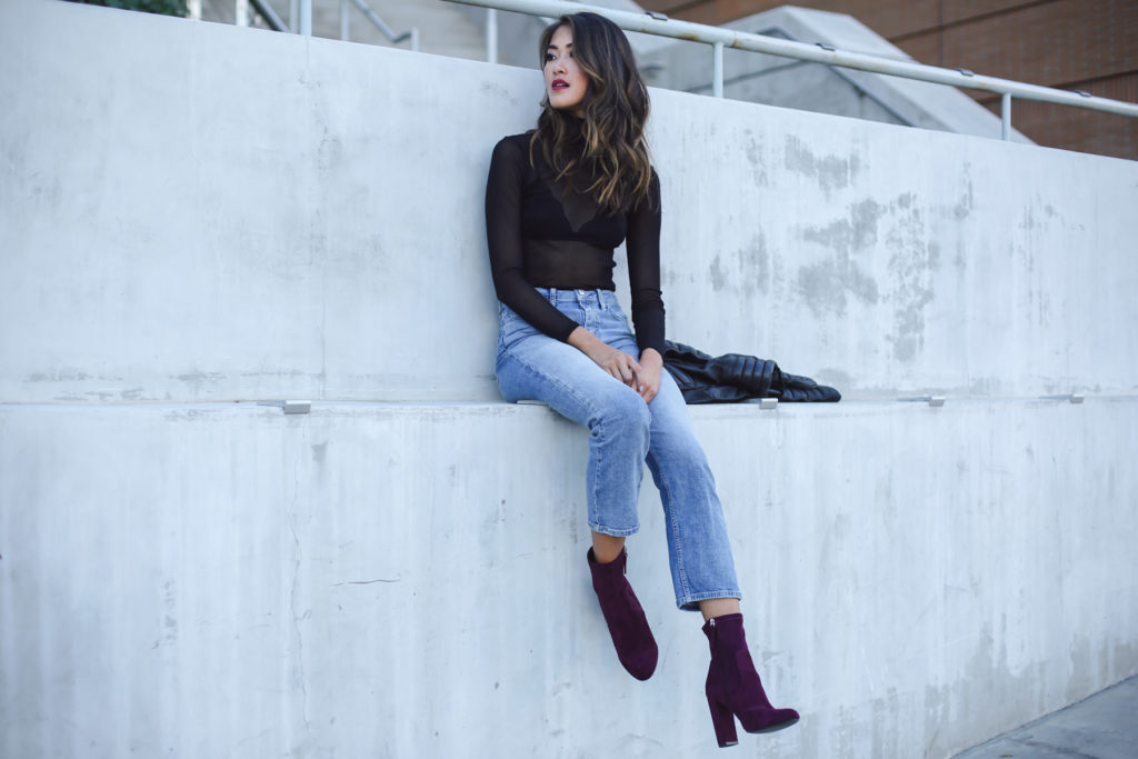 woman wearing Mesh Turtleneck, jeans, and boots