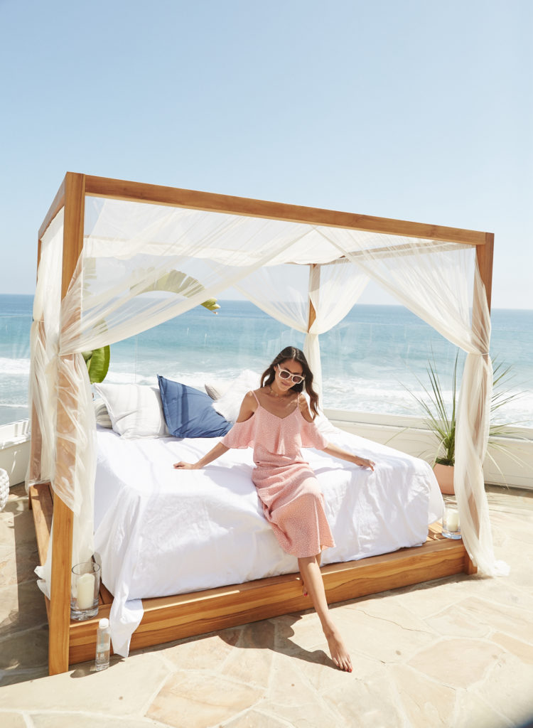 woman wearing pink dress and sitting on a day bed at Foray Malibu and sharing Business of Blogging